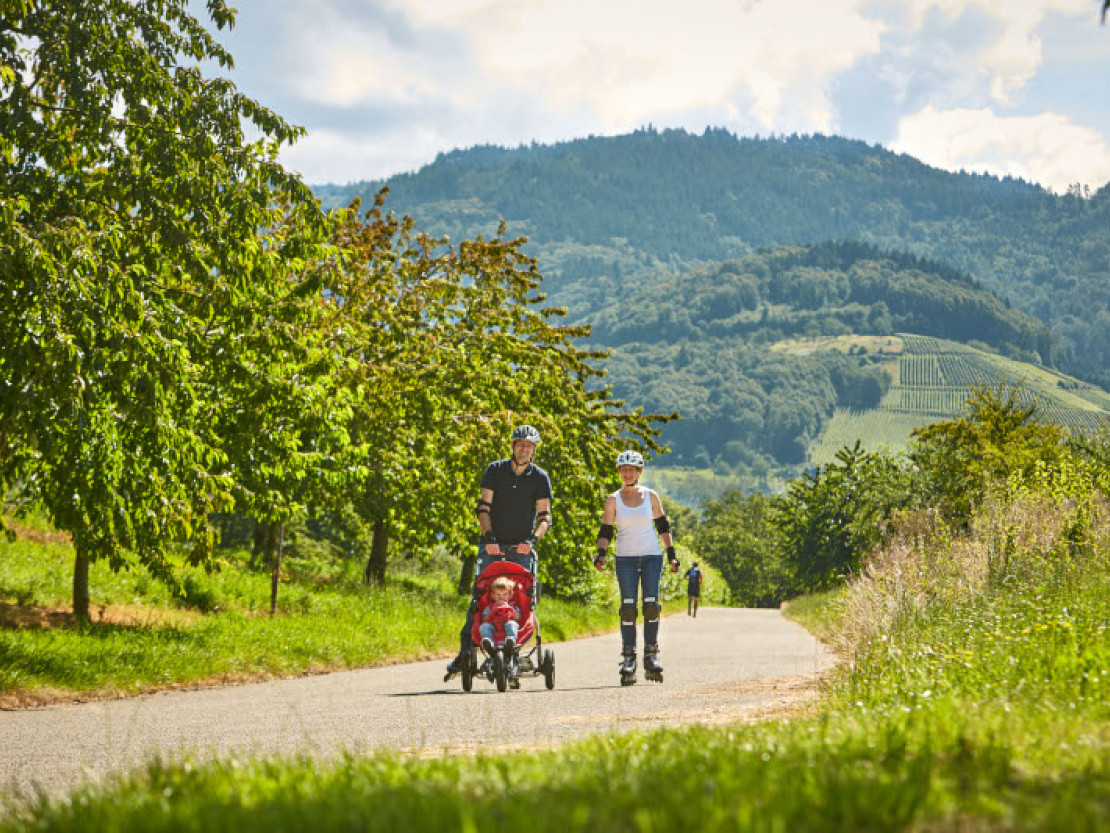 web-bf-bawu-familien-ferienFamilie bei Inlinertour durchs Achertal entlang von Obstwiesen