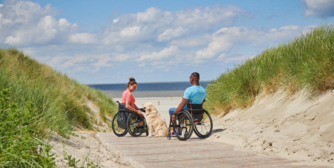 news-2022-be-thiel-pr-ostfriesland-langeoog-paerchen-mit-rollstuehlen-am-strand-dzt-jens-wegener-titel